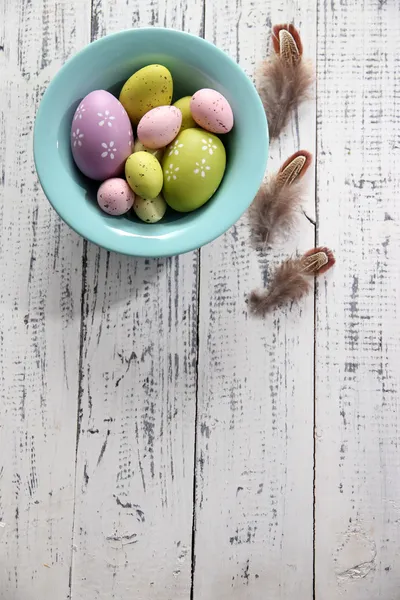 Telur Paskah dalam mangkuk warna pada warna latar belakang kayu — Stok Foto