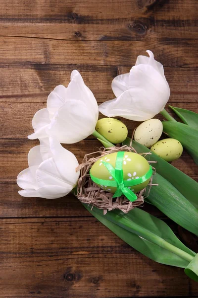 Composição com tulipas brancas e ovos de Páscoa em fundo de madeira — Fotografia de Stock