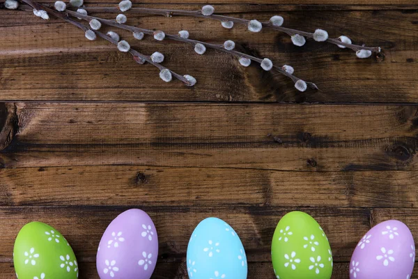 Easter eggs and pussy-willow bud on wooden background — Stock Photo, Image