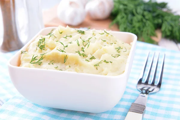 Delicious mashed potatoes with greens in bowl on table close-up — Stock Photo, Image