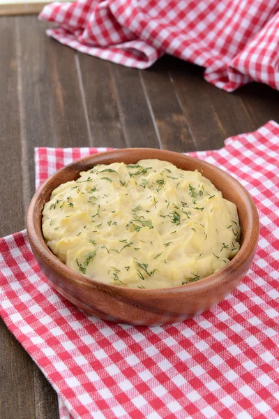 Вкусное картофельное пюре с зеленью в миске на столе крупным планом — стоковое фото