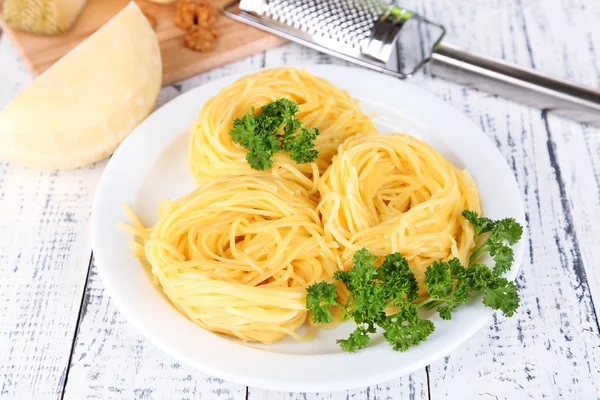 Composición con sabrosos espaguetis, rallador, queso, sobre fondo de mesa de madera —  Fotos de Stock