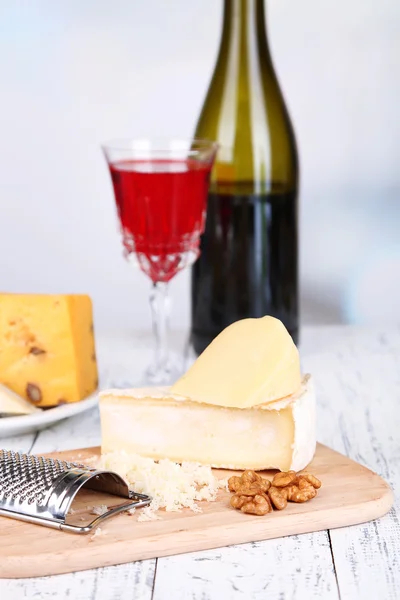 Composición con sabrosos espaguetis, queso, botella de vino y copa sobre mesa de madera, sobre fondo claro —  Fotos de Stock