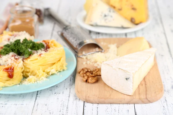 Samenstelling met lekkere spaghetti, rasp, kaas, op houten tafel achtergrond — Stockfoto