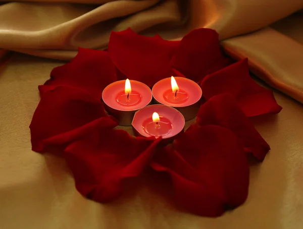 Hermosos pétalos de rosa roja con velas, de cerca —  Fotos de Stock