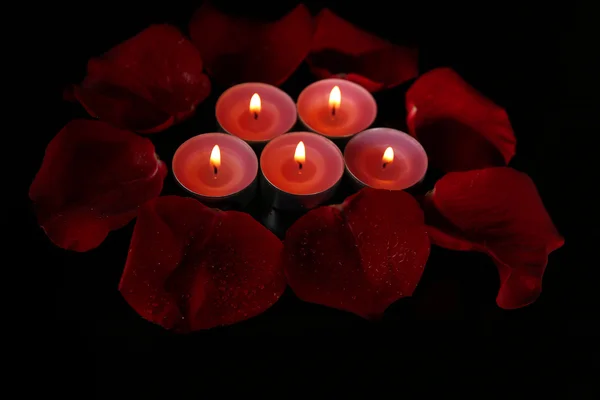 Beautiful rose petals with candle, on dark background — Stock Photo, Image