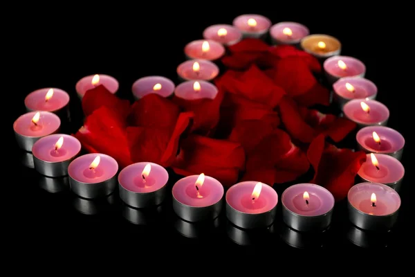 Красивые лепестки роз со свечами, на темном фоне — стоковое фото