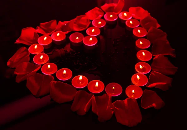 Beautiful rose petals with candle, on dark background — Stock Photo, Image