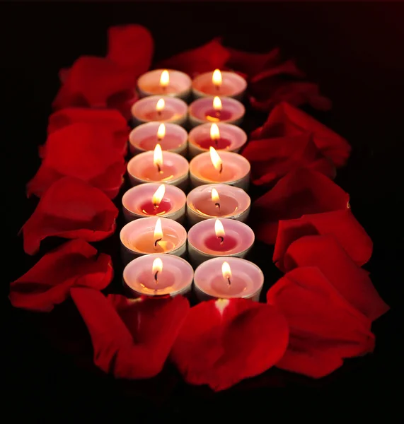 Beautiful rose petals with candle, on dark background — Stock Photo, Image