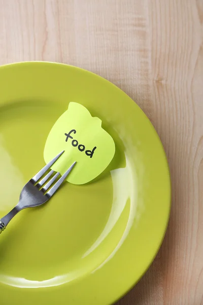 Note paper with message  attached to fork, on plate, on color wooden background — Stock Photo, Image