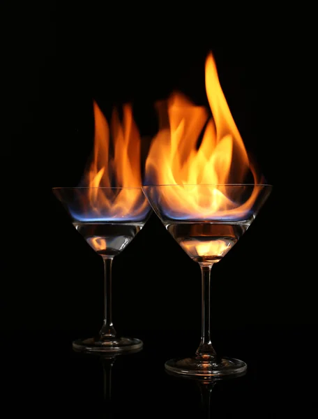 Glasses with burning alcohol on black background Stock Image