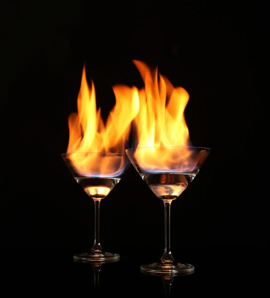 Glasses with burning alcohol on black background Stock Photo