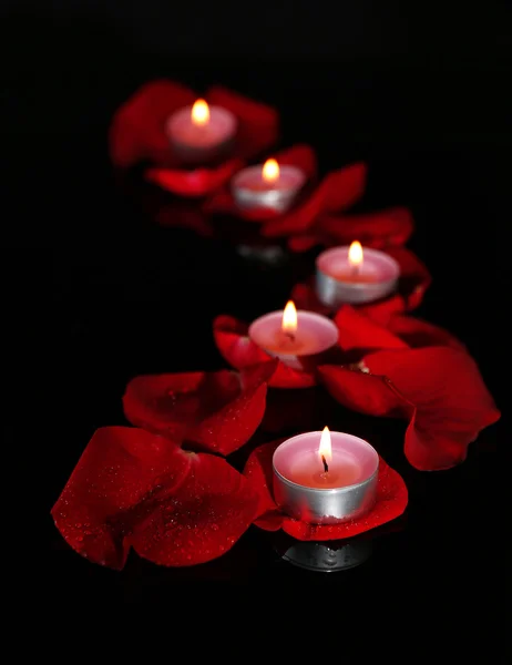 Beautiful rose petals with candle, on dark background — Stock Photo, Image