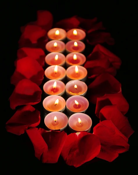 Beautiful rose petals with candle, on dark background — Stock Photo, Image