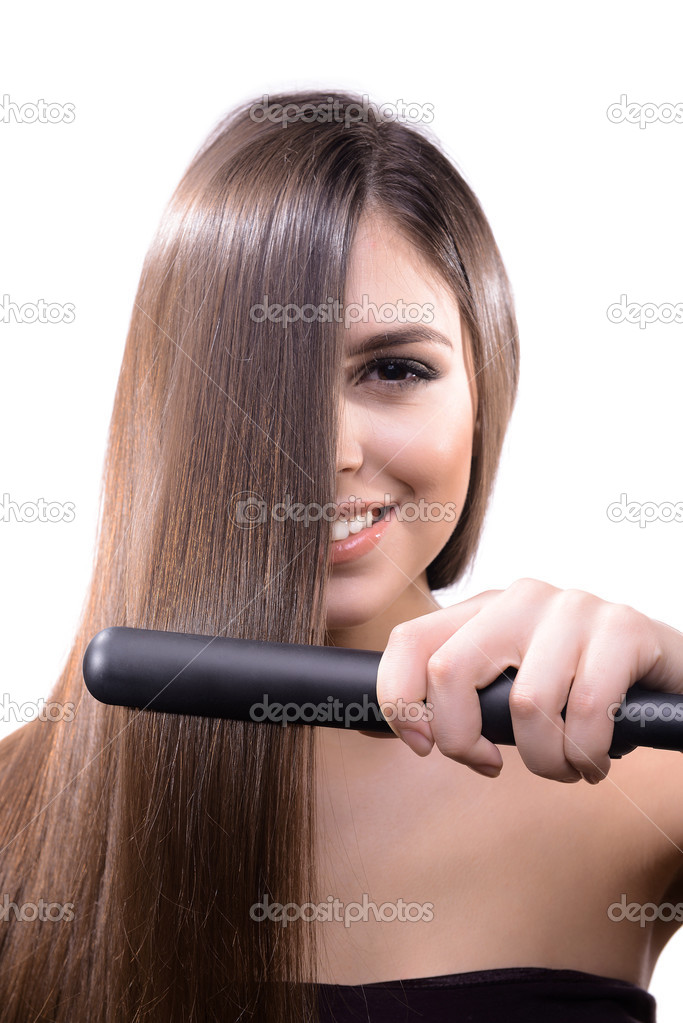 Woman doing hairstyle with hair straightener isolated on white