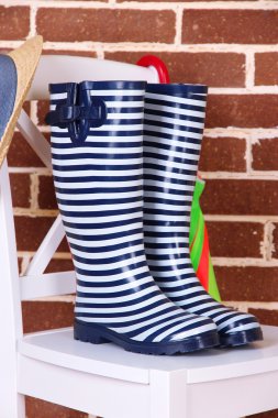 sandalyede renkli duvar arka plan üzerinde renkli gumboots çifti