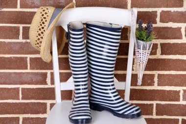 sandalyede renkli duvar arka plan üzerinde renkli gumboots çifti