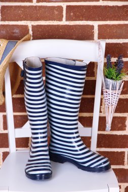 sandalyede renkli duvar arka plan üzerinde renkli gumboots çifti