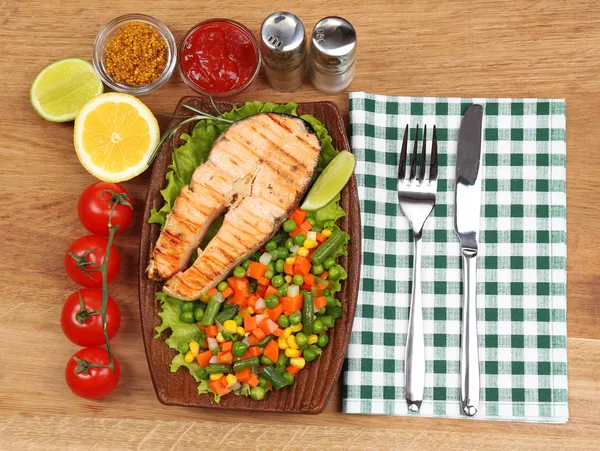 Gustoso salmone grigliato con verdure, su tavola di legno — Foto Stock