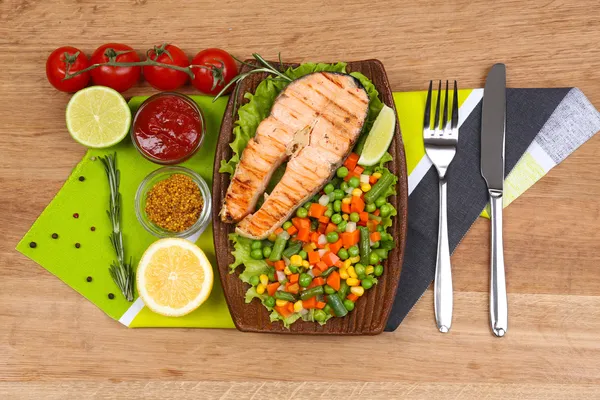 Tasty grilled salmon with vegetables, on bamboo mat — Stock Photo, Image
