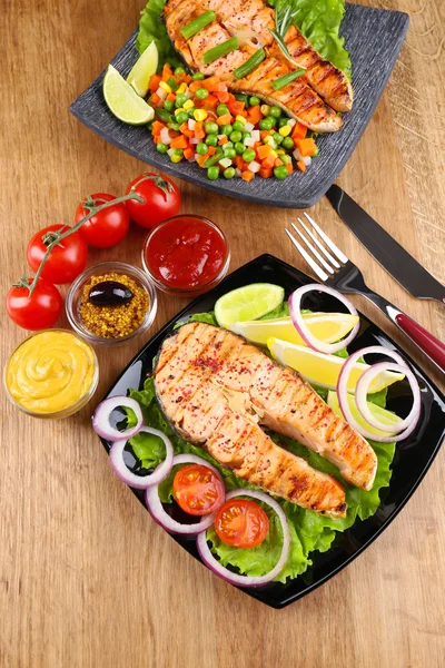 Lekkere gegrilde zalm met citroen en fruit, op houten tafel — Stockfoto