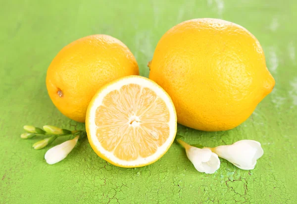 Свежие лимоны и лаванда на зеленом столе — стоковое фото