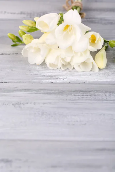 Beautiful freesias on wooden table — Stock Photo, Image