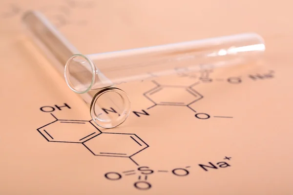 Test tube and reaction formula, close-up — Stock Photo, Image