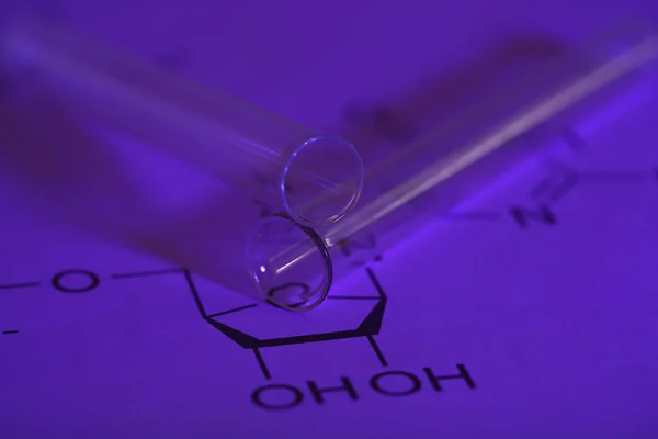 Test tube and reaction formula, close-up — Stock Photo, Image