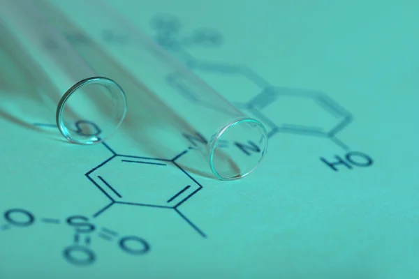 Test tubes and reaction formula, close-up — Stock Photo, Image