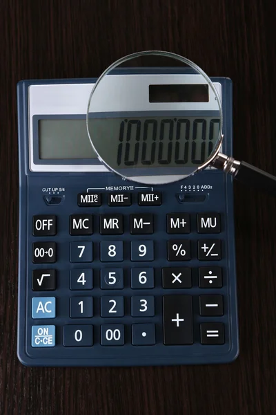 Fraude concept met Vergrootglas en rekenmachine, op houten achtergrond — Stockfoto