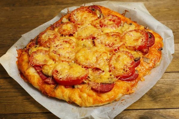 Pizza caseira em papel de assar close-up — Fotografia de Stock