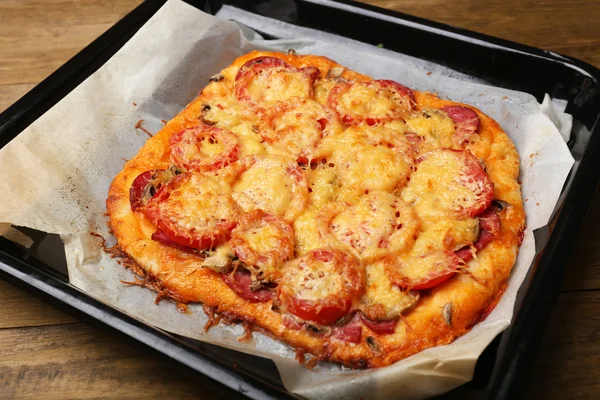Домашня піца на папері для випічки крупним планом — стокове фото