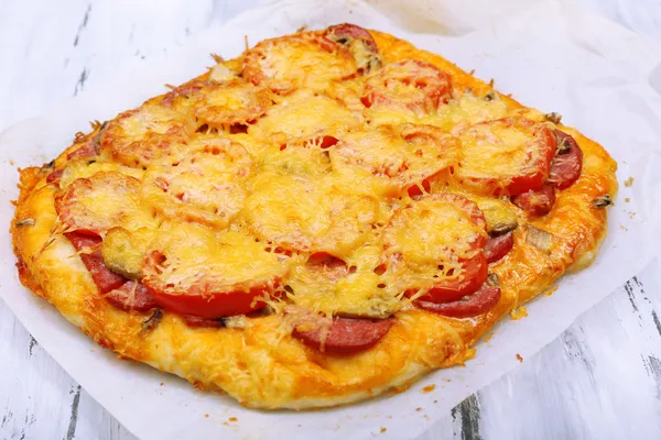 Pizza fatta in casa su carta da forno da vicino — Foto Stock