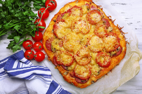 Homemade pizza on baking paper close up