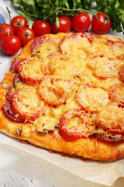 Pizza fatta in casa su carta da forno da vicino — Foto Stock