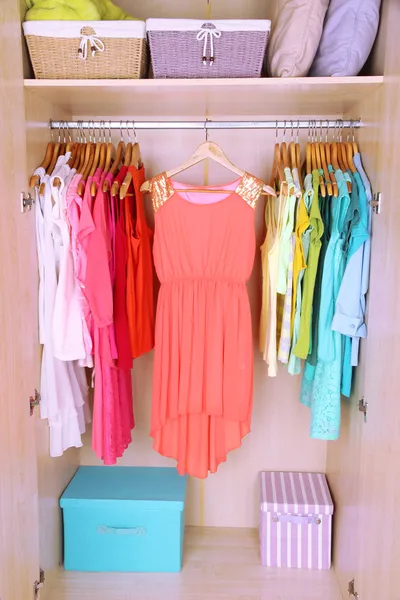 Colorful clothes hanging in wardrobe — Stock Photo, Image