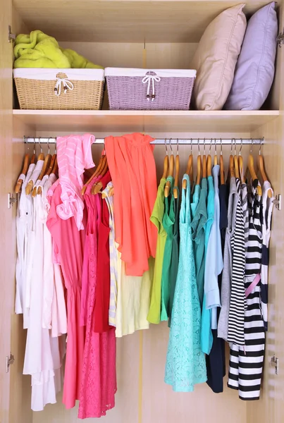 Female clothes on hangers in wardrobe — Stok fotoğraf