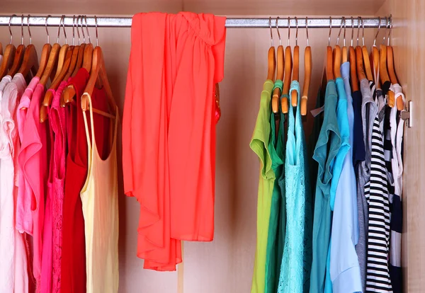 Female clothes on hangers in wardrobe — Stockfoto