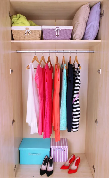 Female clothes on hangers in wardrobe — Stok fotoğraf