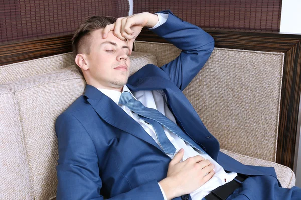 Młody biznesmen odpoczynku na kanapie w biurze — Zdjęcie stockowe