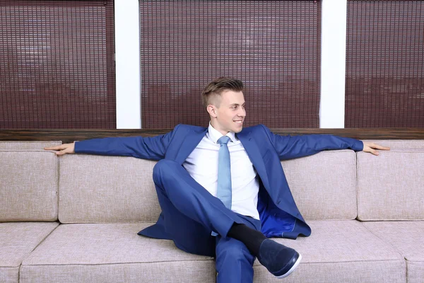 オフィスのソファで休んで若いビジネスマン — ストック写真
