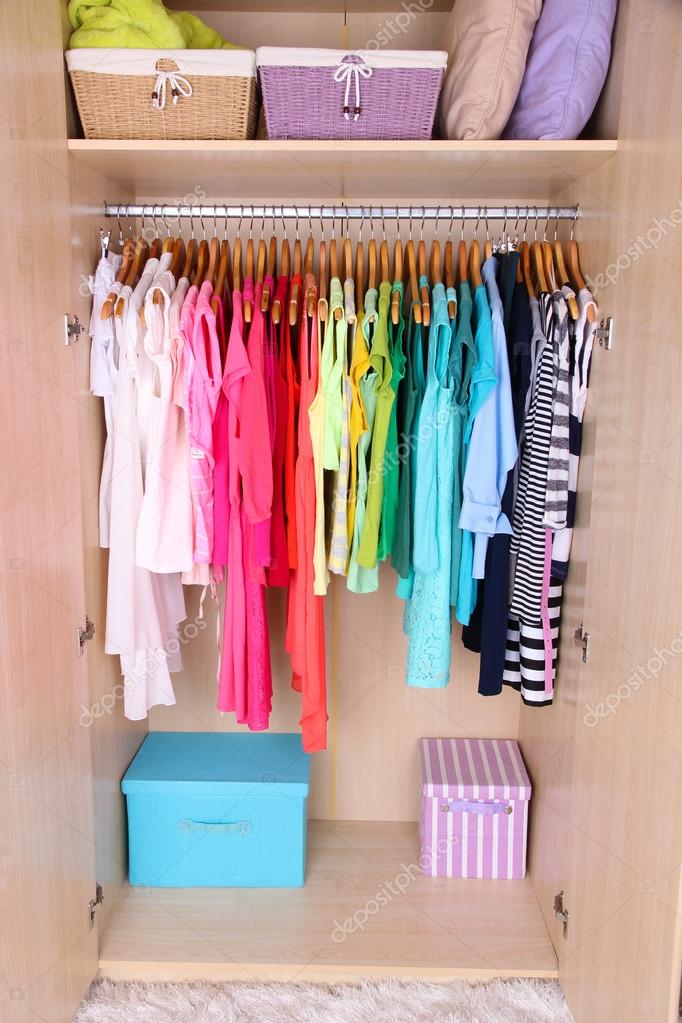 Colorful clothes hanging in wardrobe — Stock Photo © belchonock 43606233