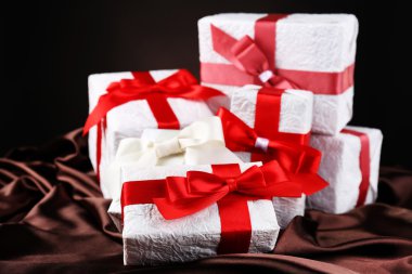 ipek, koyu arka plan üzerinde kırmızı şeritler ile güzel hediyeler