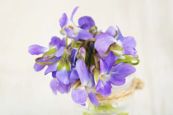 Violets flowers on wooden table — Stock Photo, Image