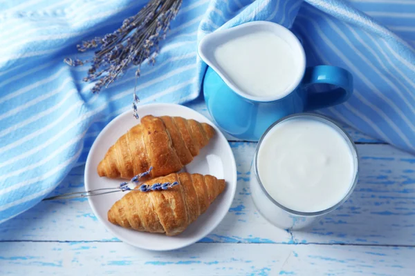 Homemade yogurt in jug and tasty croissants on wooden table background — Stock Photo, Image