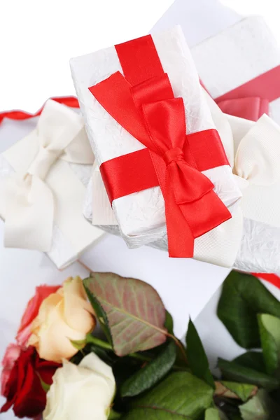 Krásné dárky s červené stuhy a květiny, zblízka — Stock fotografie