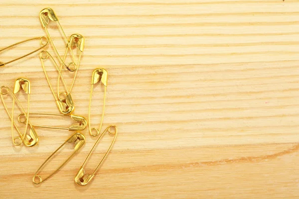 Safety pins on wooden background — Stock Photo, Image