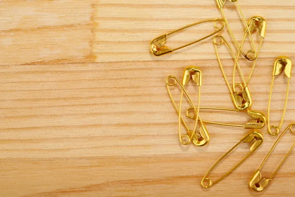 Safety pins on wooden background — Stock Photo, Image