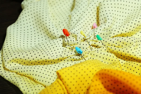 Safety pins on fabric background — Stock Photo, Image